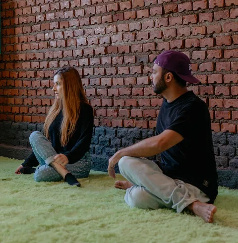 Duas pessoas do time da Prod conversando sentadas na grama, durante atividade do prodCARE.