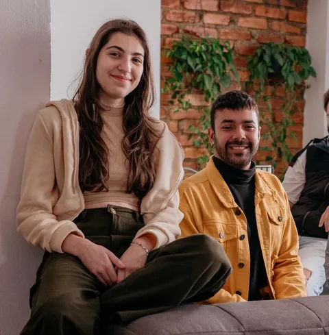 Duas pessoas do time da Prod sorrindo, sentadas lado a lado em ação do prodSOUL.